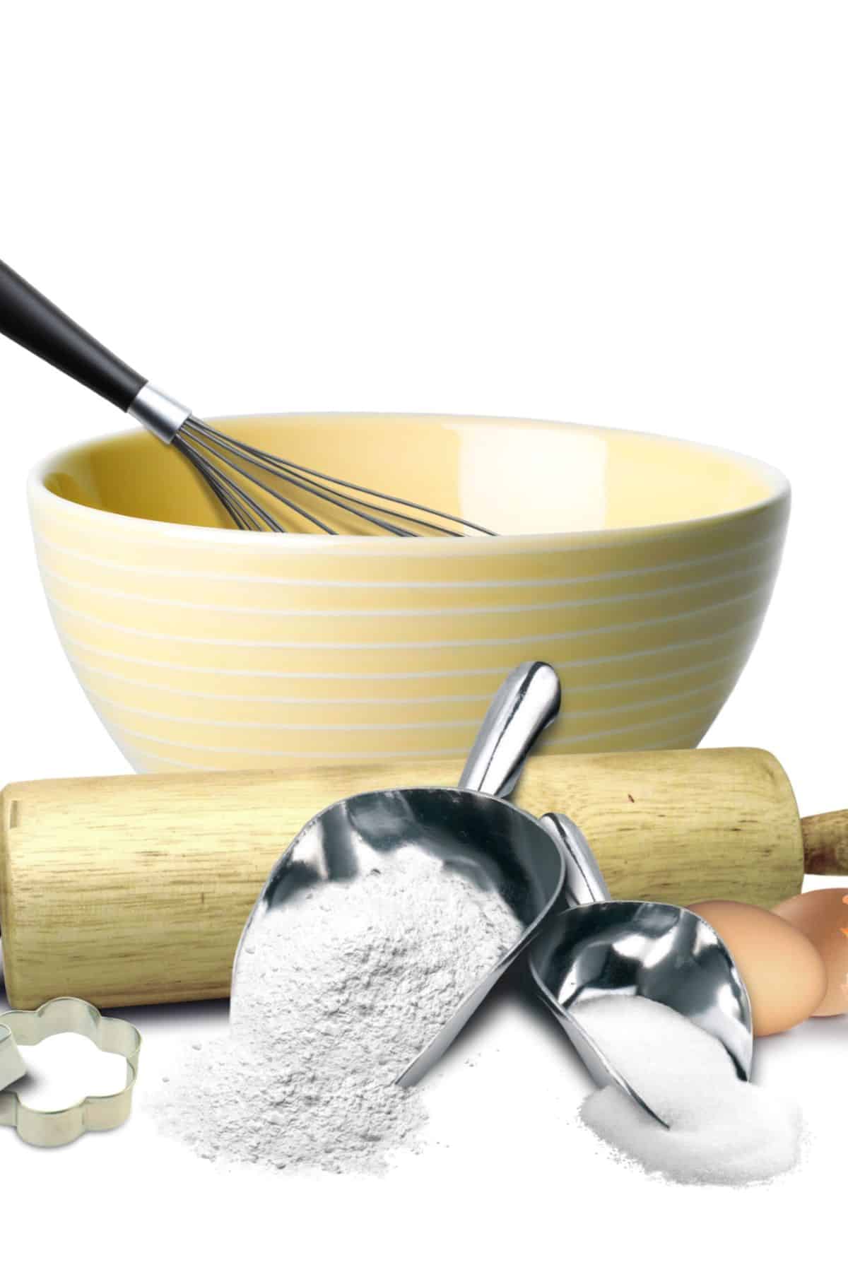 Bowl, rolling pin, measuring cup of flour, and eggs