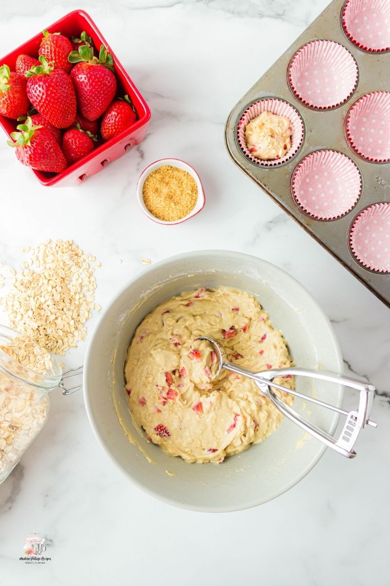 Scooping out batter to make Strawberry Oatmeal Muffins