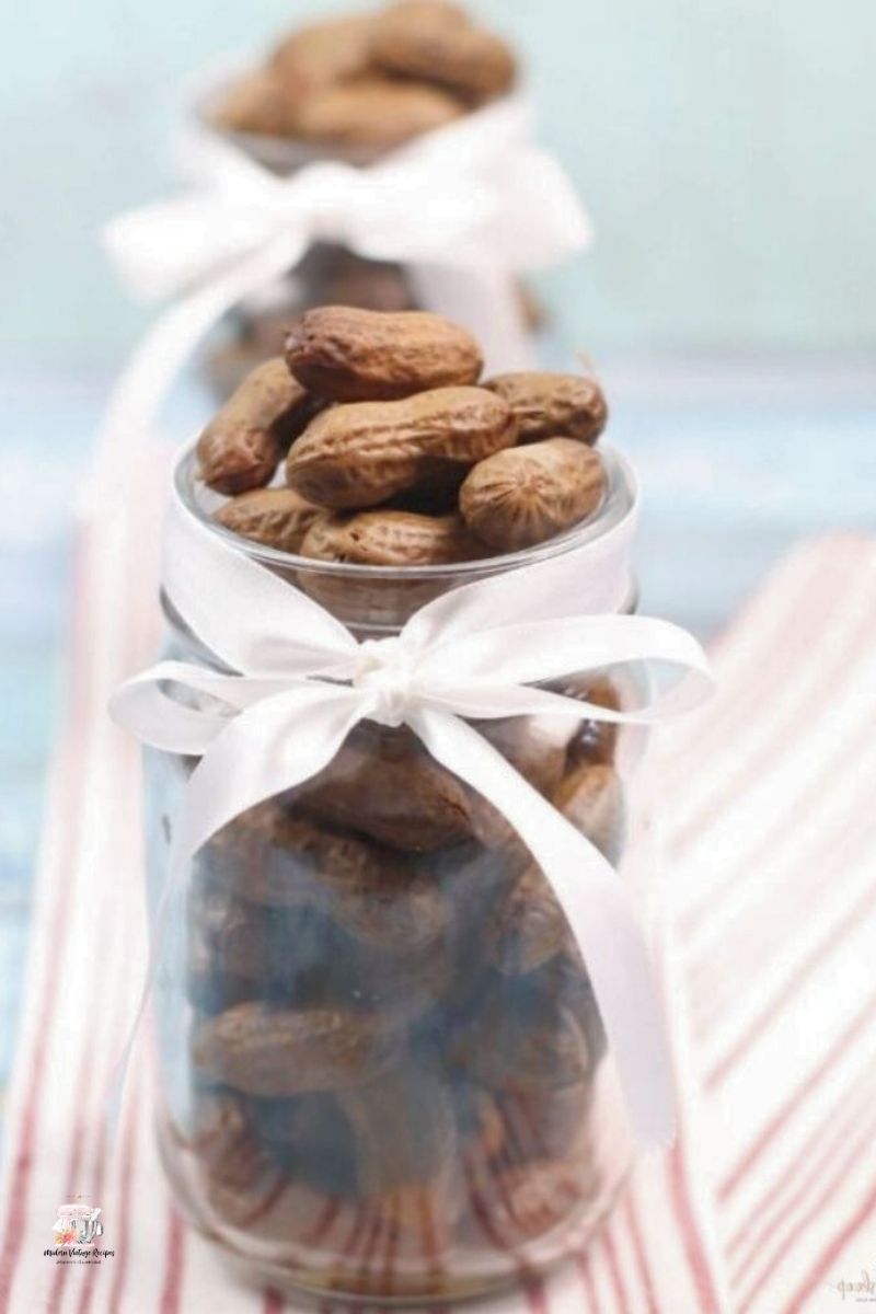 Southern style Boiled Peanuts in a glass jar with a white ribbon tied around it. 