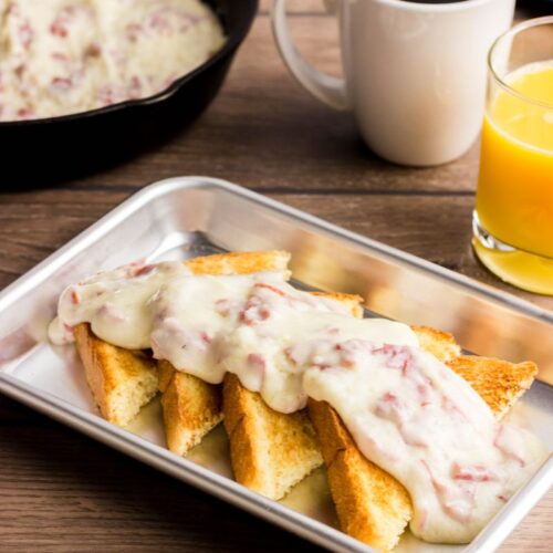 Chipped beef on toast in a stainless steel pan.