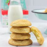 5 Snickerdoodle cookies stacked on top of each other with a glass of milk.