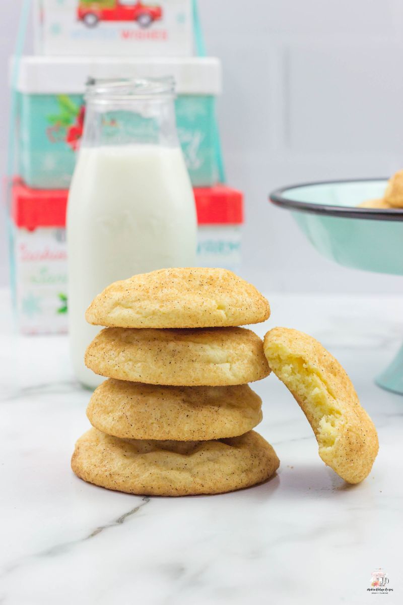 5 Snickerdoodle cookies stacked on top of each other with a glass of milk. 
